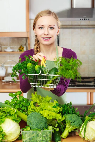 Femme dans la cuisine ayant des légumes tenant panier — Photo