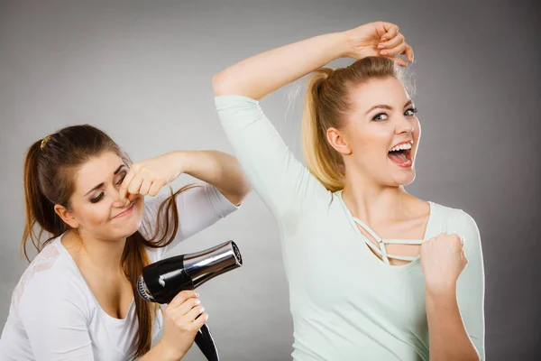 Mulher secagem amigo axila com secador de cabelo — Fotografia de Stock