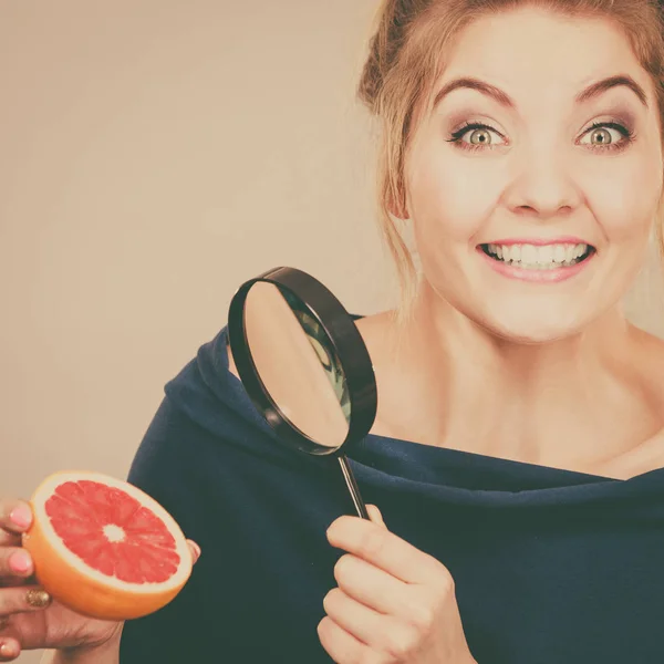 Žena držící magniferlooking grapefruit — Stock fotografie