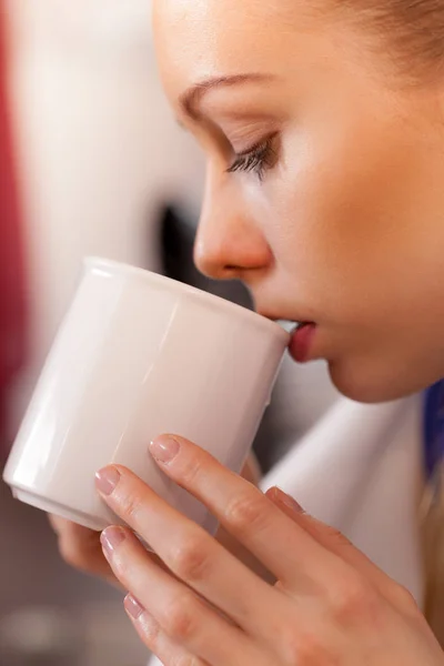 Primer plano de la mujer bebiendo de taza blanca — Foto de Stock