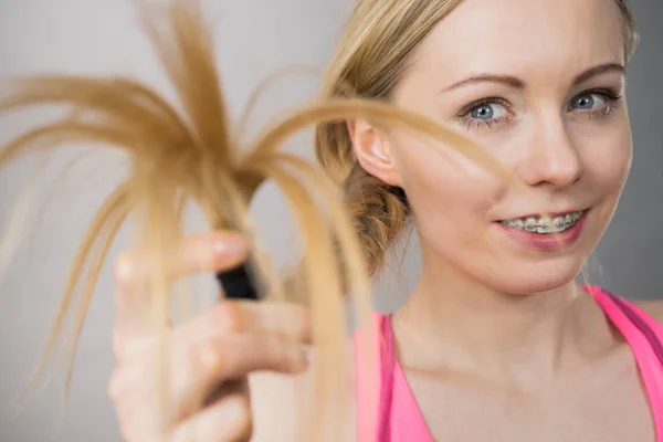 Mulher feliz olhando para o cabelo termina — Fotografia de Stock