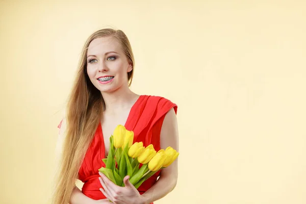 Pretty woman with yellow tulips bunch — Stock Photo, Image