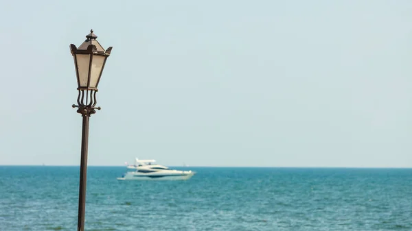 Фонарь на фоне океана с кораблем . — стоковое фото