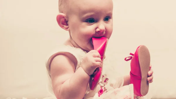 Baby girl biting shoe — Stock Photo, Image