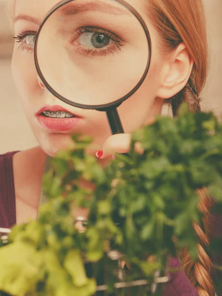 Frau blickt durch Lupe auf Gemüsekorb — Stockfoto