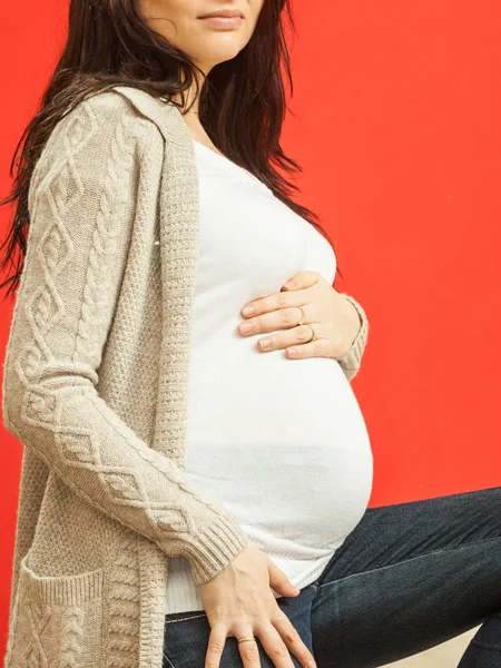 Pregnant woman in white clothes showing belly — Stock Photo, Image