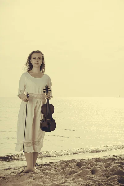 Mujer en la playa cerca del mar sosteniendo violín —  Fotos de Stock