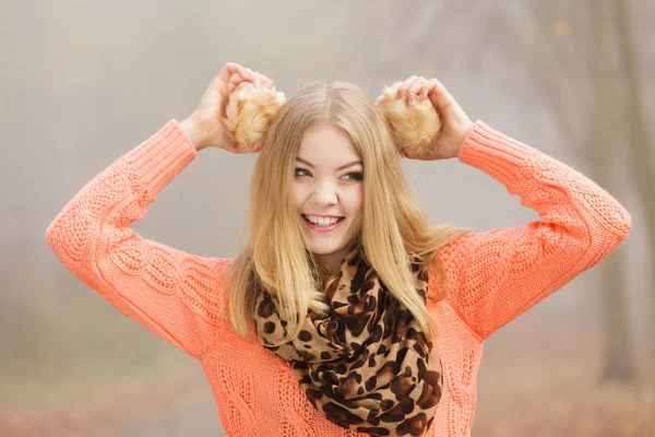 Sorridente donna di moda nel parco in possesso di paraorecchie . — Foto Stock