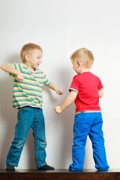 Two little boys siblings playing together on table — Stock Photo, Image