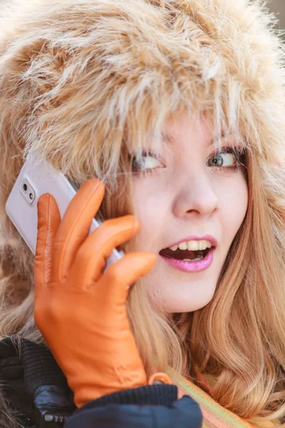 携帯電話で話している毛皮の帽子で笑顔の女性. — ストック写真