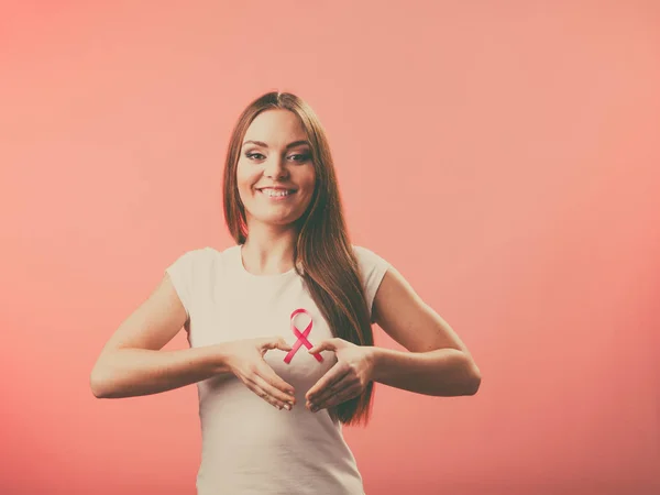 Brustkrebs. Frau macht Herzform auf rosa Schleife — Stockfoto