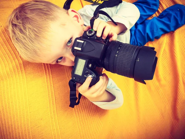 Kid playing with big professional digital camera — Stock Photo, Image