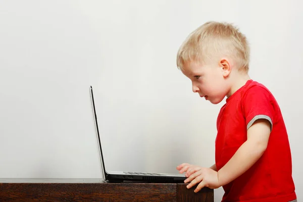 Liten pojke använder bärbar dator spelar spel — Stockfoto
