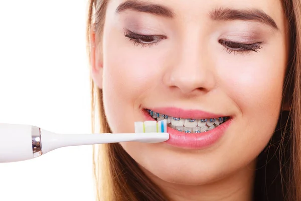 Femme brossant les dents avec des accolades en utilisant une brosse — Photo