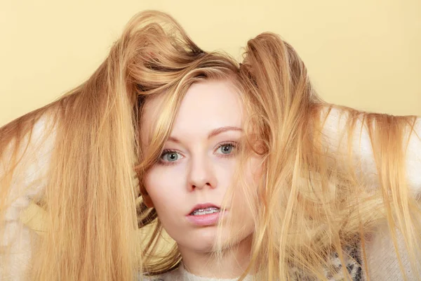Blond žena držící ji dlouho Zacuchané vlasy — Stock fotografie