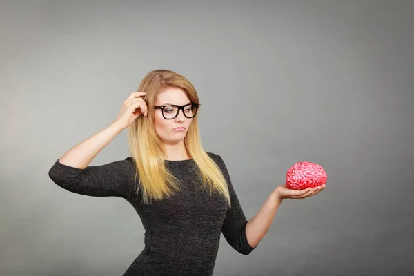 Žena v brýlích záměnu drží mozek — Stock fotografie
