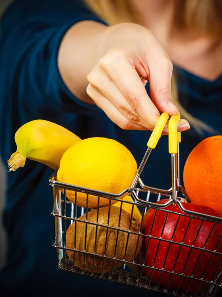 Mulher segurando cesta de compras com frutas dentro — Fotografia de Stock