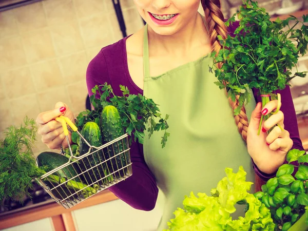 Mujer en cocina teniendo verduras sosteniendo cesta de la compra —  Fotos de Stock