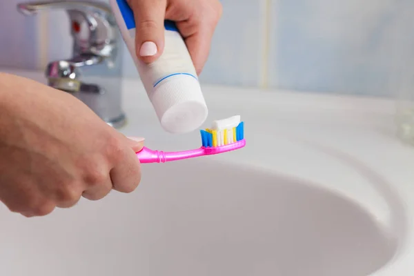 Hand tillämpas tandkräm på tandborsten — Stockfoto
