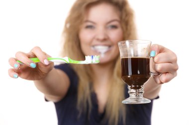 Happy woman holding toothbrush and coffee clipart