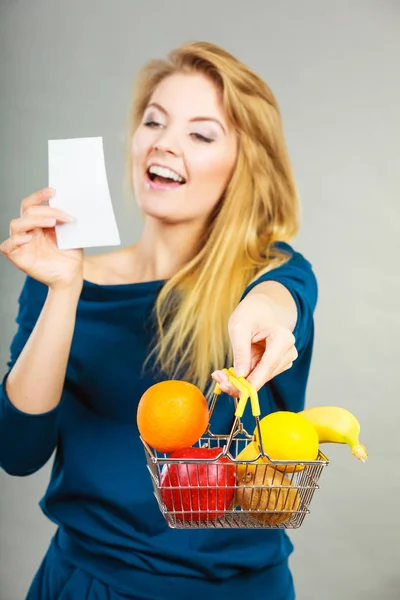 Donna felice che tiene il carrello della spesa con frutta — Foto Stock