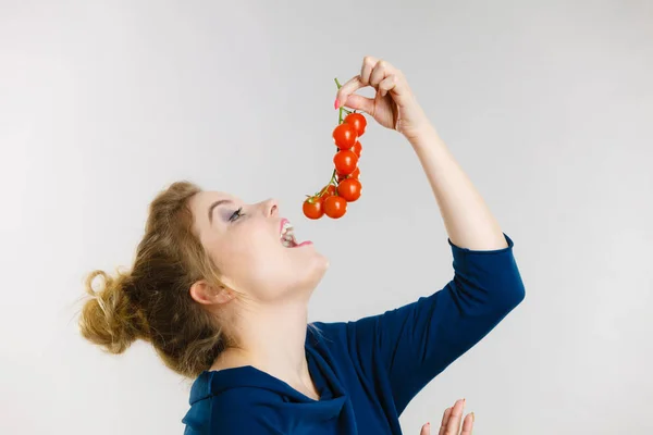 Mulher segurando tomates cereja frescos — Fotografia de Stock