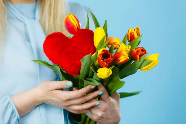 Mujer sostiene tulipanes y corazón rojo — Foto de Stock