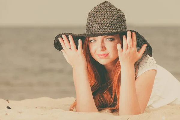 해변에 누워 태양 모자를 쓰고 빨간 머리 여자 — 스톡 사진