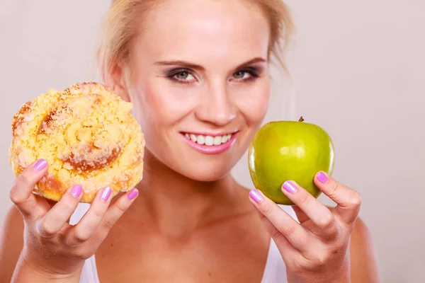 Femme tient gâteau et fruits à la main en choisissant — Photo