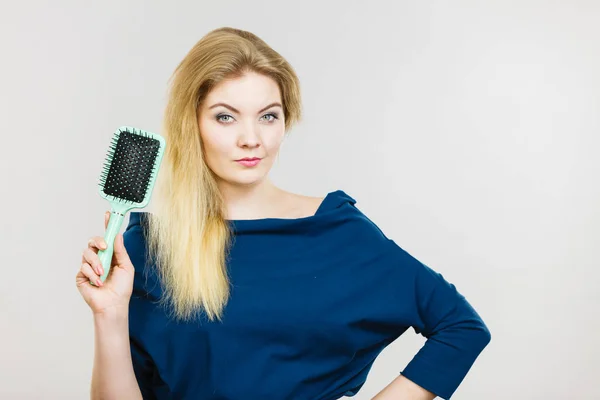 Vrouw haar lange haren borstelen met borstel — Stockfoto