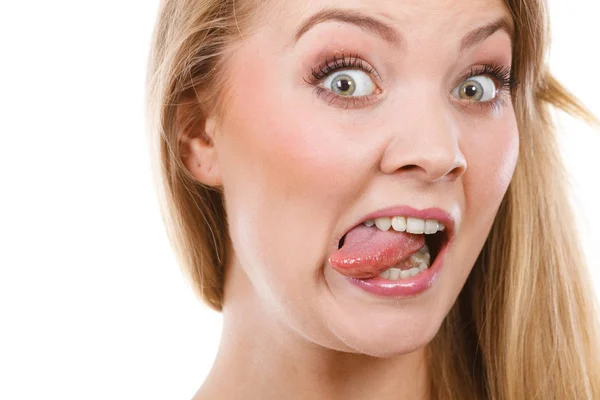 Funny blonde woman sitcking tongue out Stock Photo