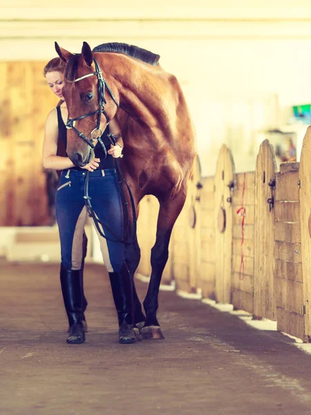 Jonge vrouw meisje in stal met paard. — Stockfoto