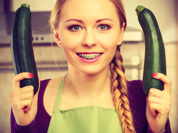 Mulher na cozinha detém abobrinha vegetal — Fotografia de Stock