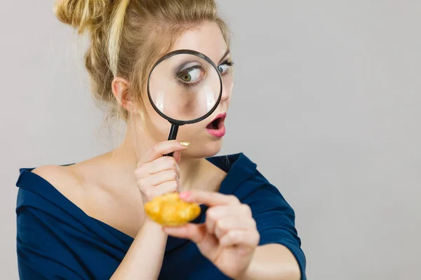 Žena držící lupy vyšetřování chléb — Stock fotografie