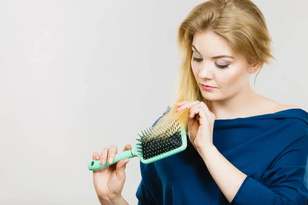 Frau bürstet ihre langen Haare mit Pinsel — Stockfoto