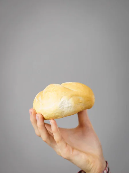 Woman hand holding bun bread roll. — Stock Photo, Image