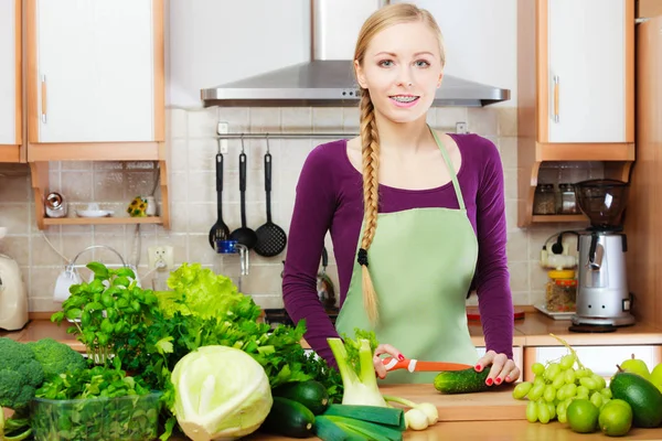 Kvinna-hemmafru i kök med gröna grönsaker — Stockfoto