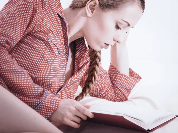 Woman relaxing in bed reading book — Stock Photo, Image