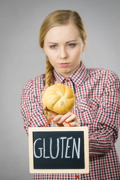Mulher segurando placa com sinal de glúten e pão de pão — Fotografia de Stock
