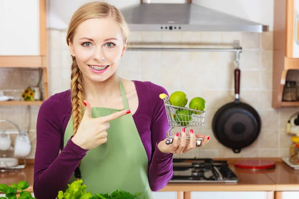 Vrouw met winkelwagentje met limesinside — Stockfoto