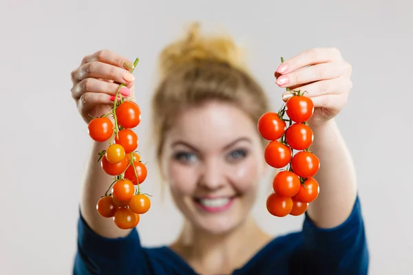Mujer sosteniendo tomates cherry frescos — Foto de Stock