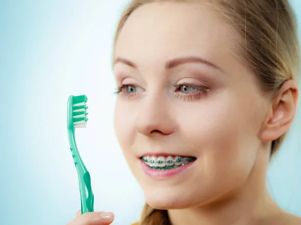 Femme avec des appareils dentaires à l'aide d'une brosse — Photo