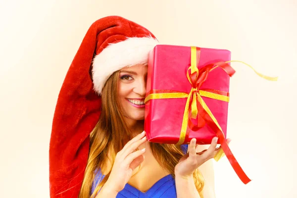 Vrouw in Kerstman hoed houdt geschenkdoos. Kersttijd — Stockfoto