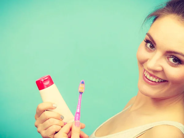 Mujer sostiene cepillo de dientes y pasta para la limpieza de dientes —  Fotos de Stock