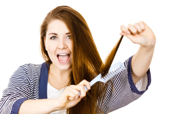 Femme brossant ses cheveux longs à l'aide d'un peigne — Photo