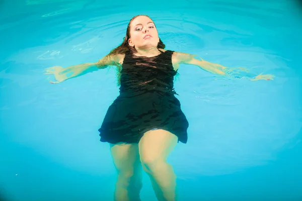 Mujer flotando relajante en el agua de la piscina . — Foto de Stock