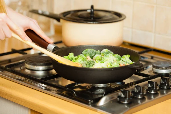 Mulher cozinhar fritar legumes congelados na panela — Fotografia de Stock