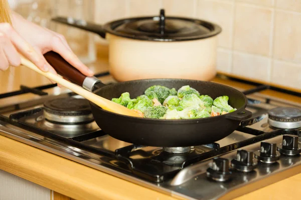 Frau beim Kochen unter Rühren gefrorenes Gemüse in Pfanne braten — Stockfoto