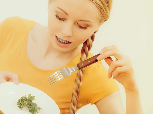 Jovem sorrindo mulher comendo alface — Fotografia de Stock