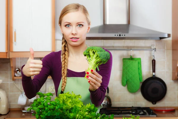 Femme dans la cuisine avec des légumes verts brocoli à la main — Photo